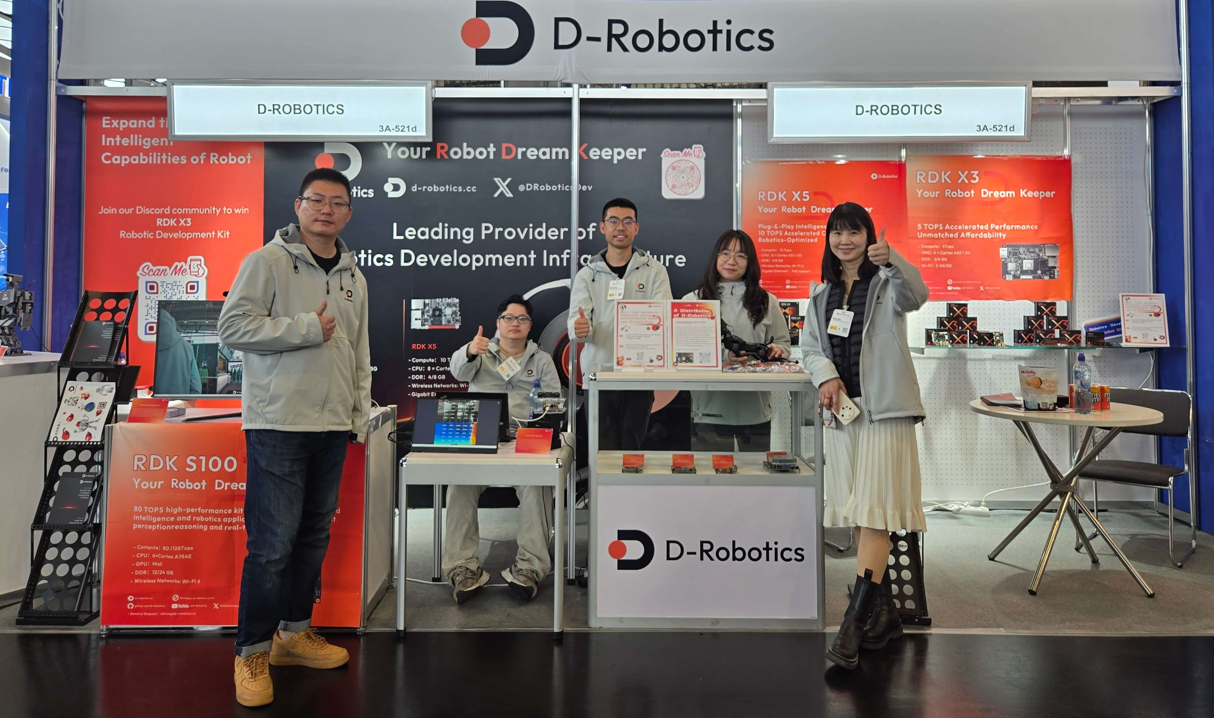 At the D-Robotics booth, several people in uniform smile and give a thumbs - up, showcasing robot development - related products, conveying a positive and professional brand atmosphere.